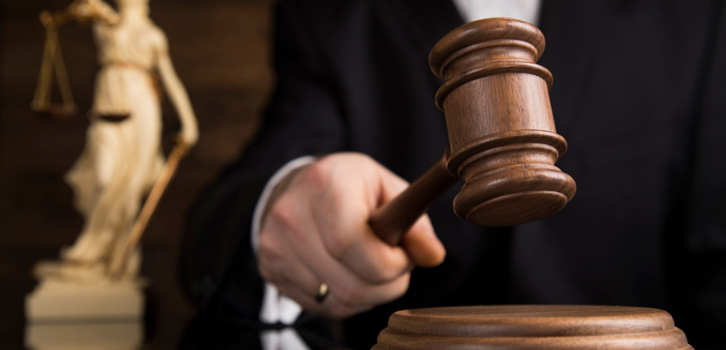 Photo of a man in a courtroom using a gavel