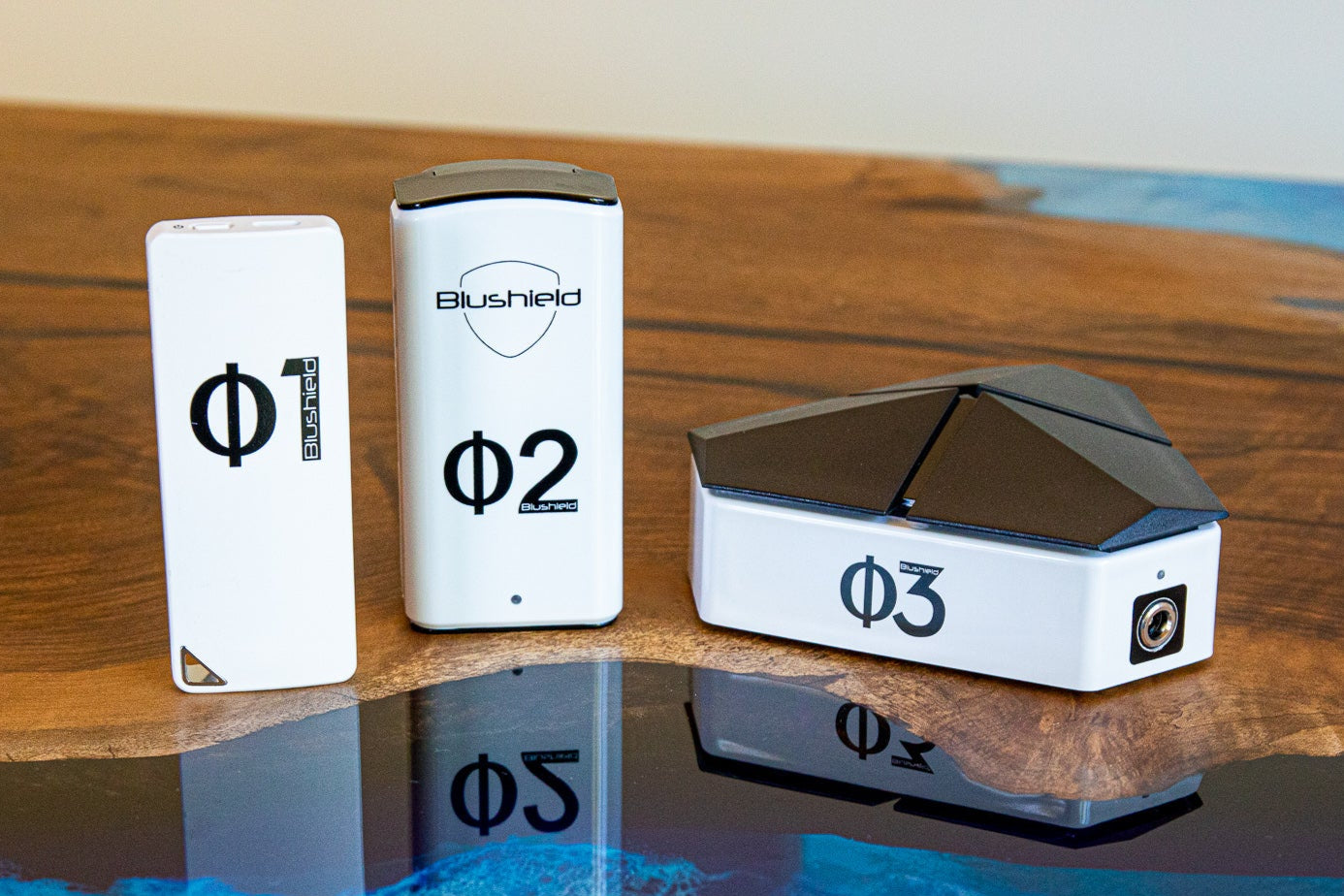 EMF PROTECTION  - product lineup of Phi 1, Phi 2, and Phi 3 on a wooden table