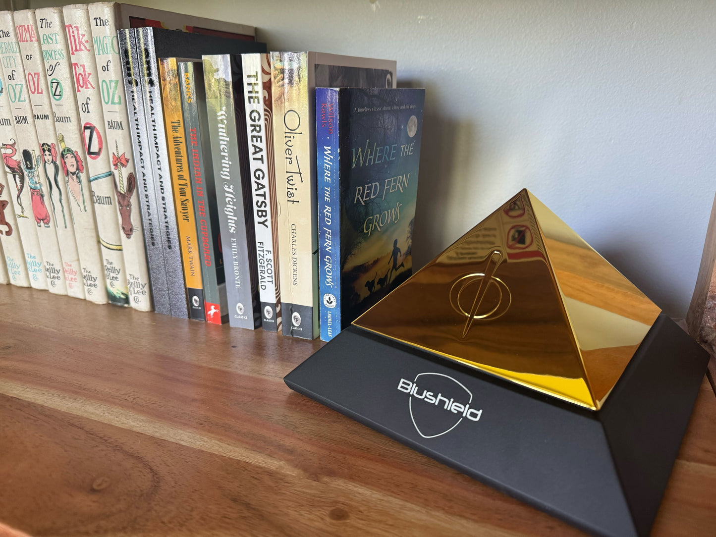 The EVO Pyramid sits on a shelf next to a collection of books