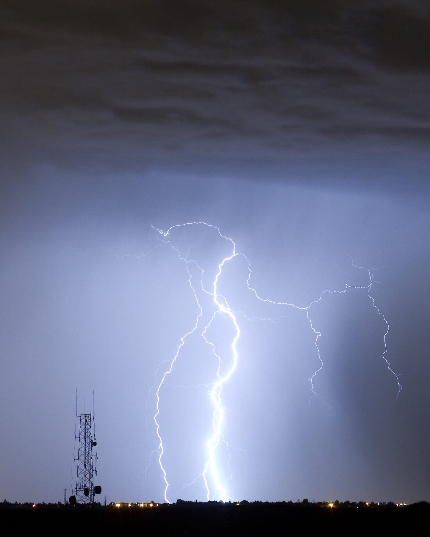 Image of a big lightning bolt next to a cell tower