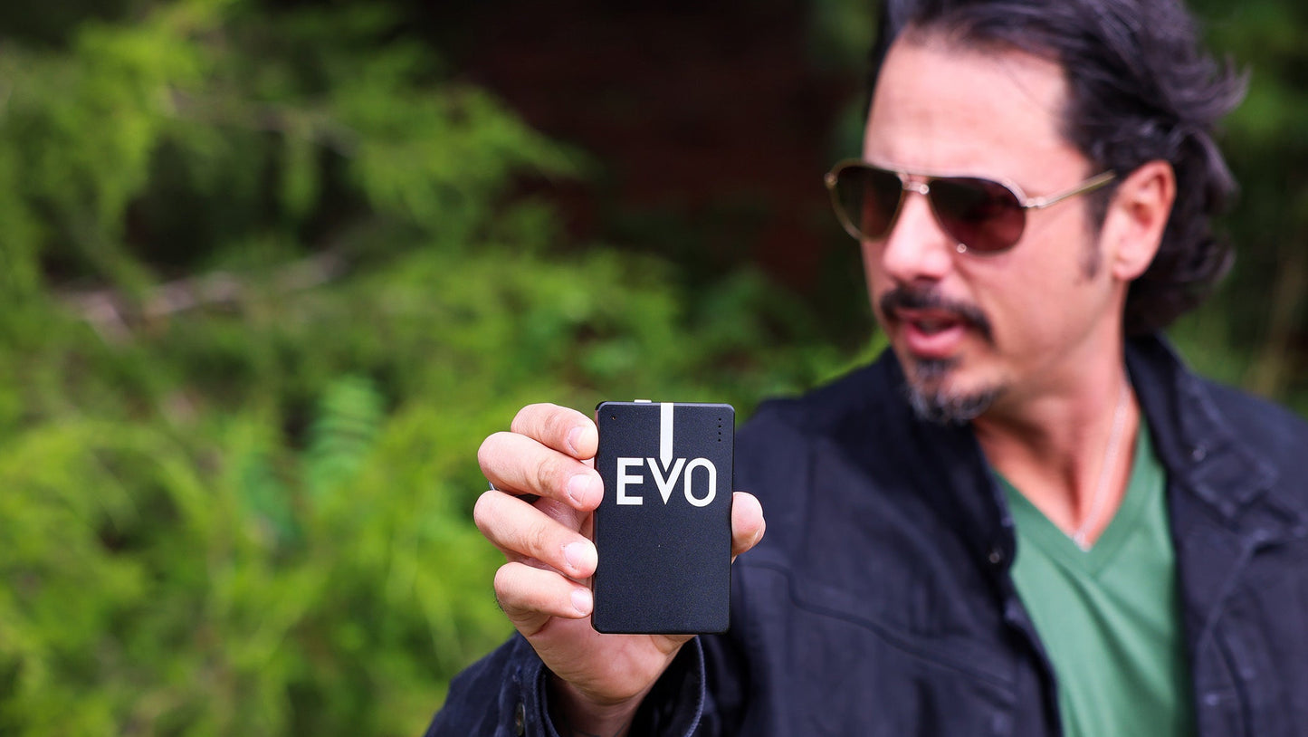Man holding a phone with 'EVO' branding outdoors